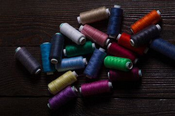 A set of multicolour sewing threads laying on a wooden background