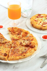 Thin Pizza with Melted Cheese Topping, Served on White Plate with Orange Soda. Concept for White Bakery or Pizza House
