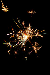 One bengal fire sparkles against the black background.