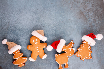 Gingerbread man, cookies and Christmas decor on pastel background.