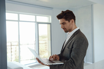 Fototapeta premium Man working remotely with laptop computer at home
