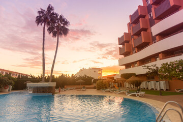 Photography of a residential area during the sunset with palms and pool
