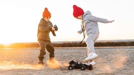 Playful baby kids driving radio controlled off road high speed sport buggy car on sand black SUV rc - obrazy, fototapety, plakaty