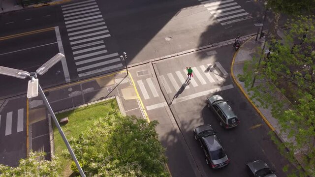 Aerial view of juggler performing at zebra crossing during red traffic light.