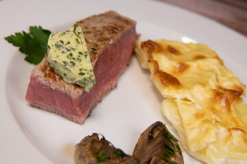 Recipe for gratin dauphinois, grilled veal steak and grilled button mushroom. High quality photo
