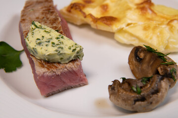 Recipe for gratin dauphinois, grilled veal steak and grilled button mushroom. High quality photo