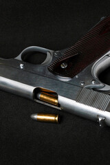 Automatic white gun stainless steel pistol weapon model m1911 with real bullet ammo head in black background