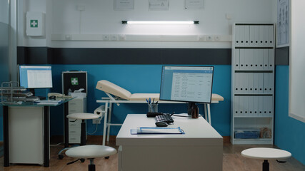 Empty doctors office for healthcare analysis and consultation. Nobody in cabinet with medical equipment and instruments for examination. Space with desk, computer and tools for checkup.