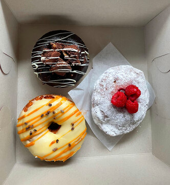 Overhead view of three doughnuts in a cardboard box