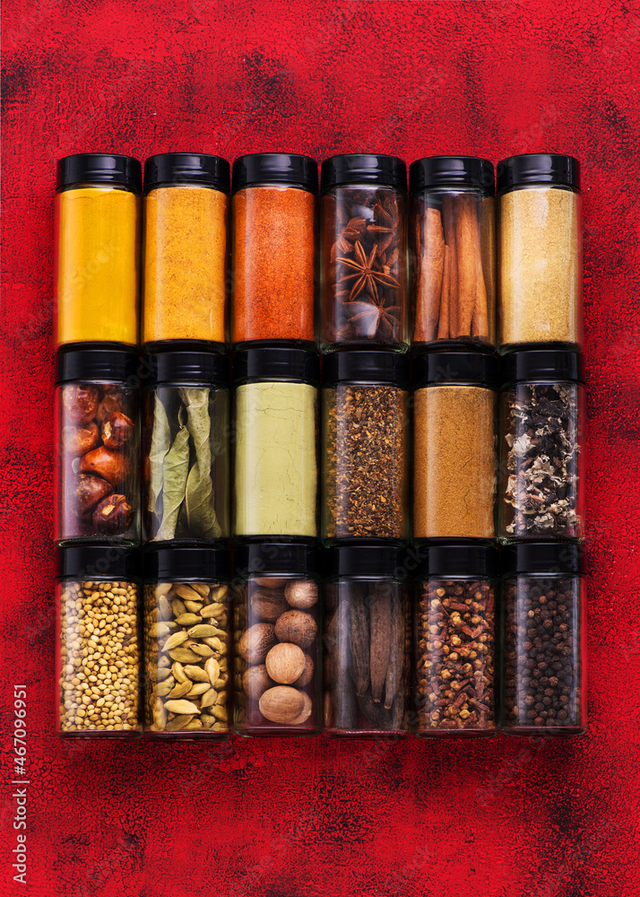 Wall mural colorful various spices, seasoning in glass jars. spices and spicy background.