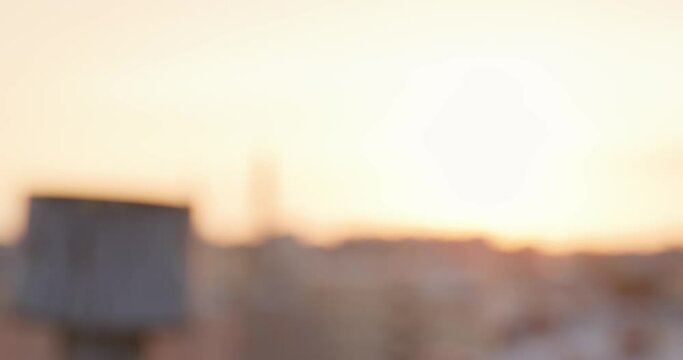Golden microphone on a stand on blurry background with dawn or sunset sky, which person abruptly grabs with hand and removes from the frame, close up, front view.