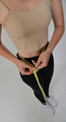 junge frau misst bauch bauchumfang bauchfett bmi taille mit massband abnehmen diät vorbild dünn...