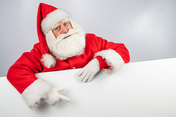 Santa Claus points to white copy space. Advertising. Merry Christmas.