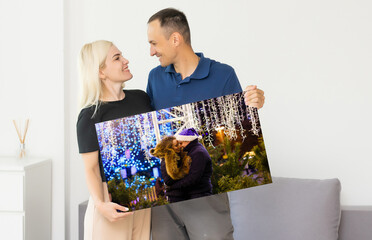 a man and a woman holding a photo canvas.