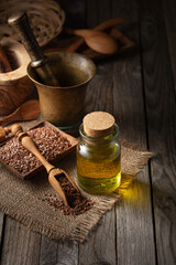 Flaxseeds and linseed oil on an old wooden table.