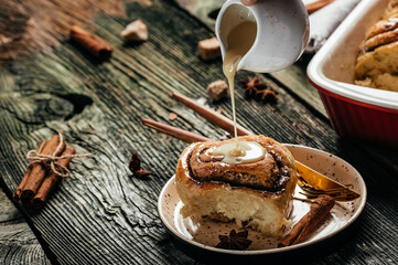 Baked cinnamon rolls with cream sauce. Food recipe background. Close up