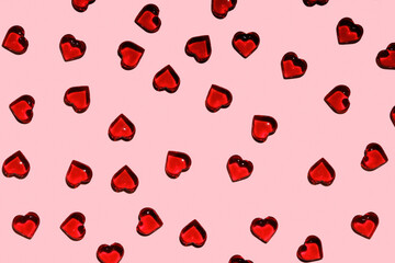 Bright background for Valentine's Day. Pattern of red plastic decorative hearts