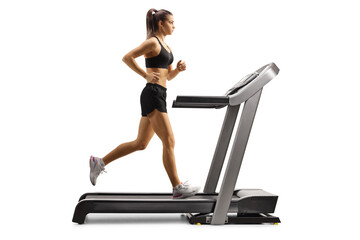 Full length profile shot of a fit young female running on a treadmill