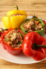 Stuffed pepper in plate on wooden background