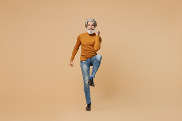 Full body fun elderly gray-haired mustache bearded man 50s in mustard yellow turtleneck shirt do...