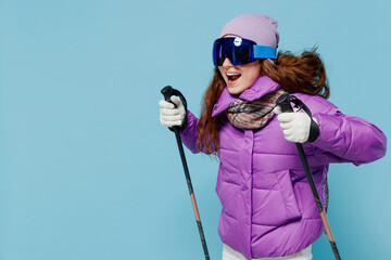 Skier smiling excited happy woman wear warm purple padded windbreaker jacket ski goggles mask spend...