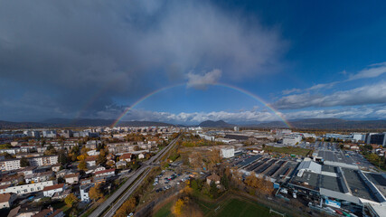 Panorama of siska district in Ljubljana, Slovenia accompanied by beautiful rainbow spanning over the horison over the Smarna Gora mouintain. Dreamy photo of a suburb.