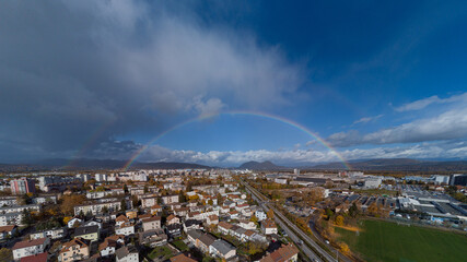 Panorama of siska district in Ljubljana, Slovenia accompanied by beautiful rainbow spanning over the horison over the Smarna Gora mouintain. Dreamy photo of a suburb.