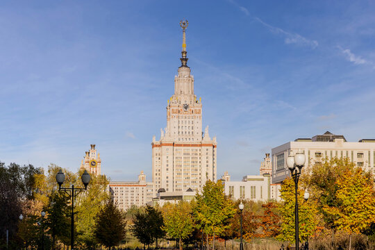 The main building of Moscow State University aka MSU or MSU on Vorobyovy Gory. Shot through an autumn park with yellowed foliage. Famous place in Russia