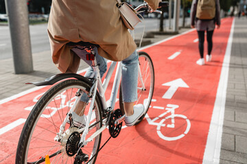 traffic, city transport and people concept - close up of woman cycling behind pedestrian walking...