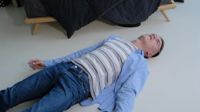 Epileptic seizure. A man struggles in convulsions while lying on the floor