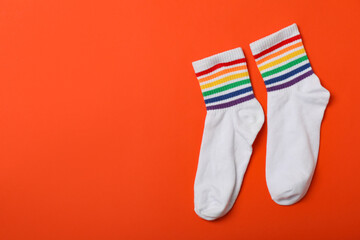 Pair of LGBT socks on orange background