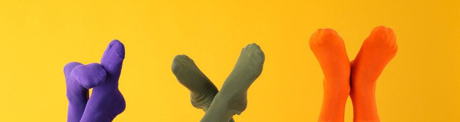 Legs in different socks on yellow background