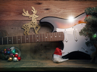 Old used vintage guitar with Christmas lights on a wooden plank