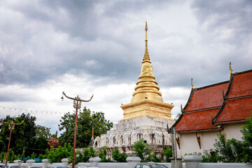 Wat Pra Tard Chang Kum Buddhist temple locate on Amphoe Mueang Nan District, Thailand with background of cloudy sky.