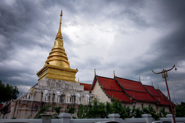 Fototapeta na wymiar Wat Pra Tard Chang Kum Buddhist temple locate on Amphoe Mueang Nan District, Thailand with background of cloudy sky.