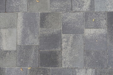 Texture of pavement made of rectangular gray concrete blocks