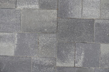 View of pavement made of rectangular gray concrete blocks from above