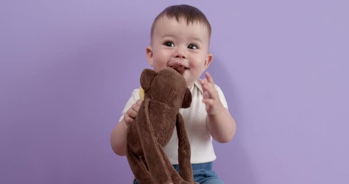 Pretty Sweet Caucasian Toddler Girl Is Playing With Toy Looking At Side, Then Throwing Toy, Beautiful Short Haired Little Kid Child Is Looking Happy, Smiling Cutely. People, Children Concept