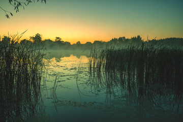 Magical sunrise over the lake. Misty morning