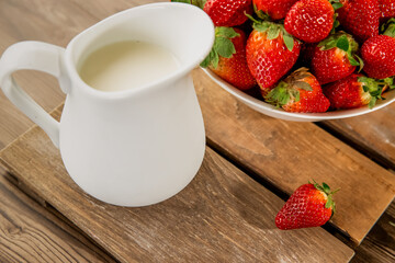 freshly picked organnic strawberry and milk on wooden table natural background, countryside, healthy eating. 
