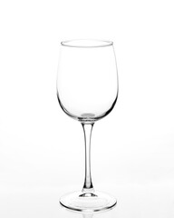 Empty wine glass on a white background. The stem of the glass is reflected in a white background.