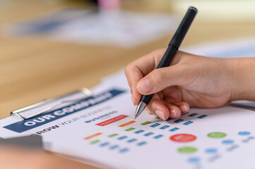 female employee holding a pen and writing on the document