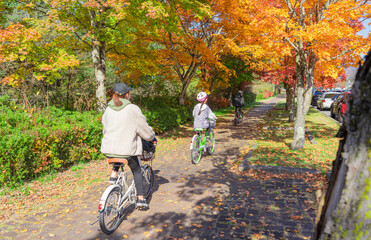 紅葉の季節に軽井沢で自転車に乗る親子