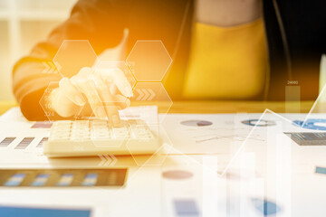 Businesswoman presses a calculator to check data on documents, company financial reports, graphics showing financial and numerical growth data. Financial management to grow and be a profitable concept