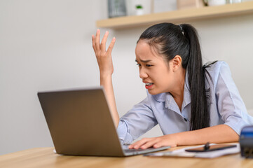 female worker using laptop and thinking