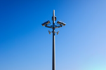 A post with several security cameras and light bulbs to control security and privacy.