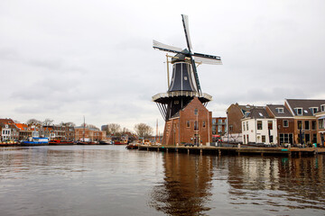 Fototapeta na wymiar Cityscape of Haarlem, the Netherlands. View of old windmill and typical Dutch houses.