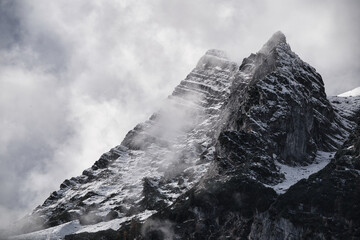 snow covered mountain peak in the fog