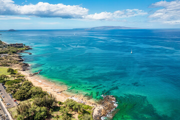 Panoramic perspective view into Teal water from beautiful Hawaiian Island of Maui with white sand beach in Kihei