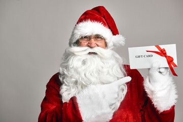 Santa Claus holding gift card in hands